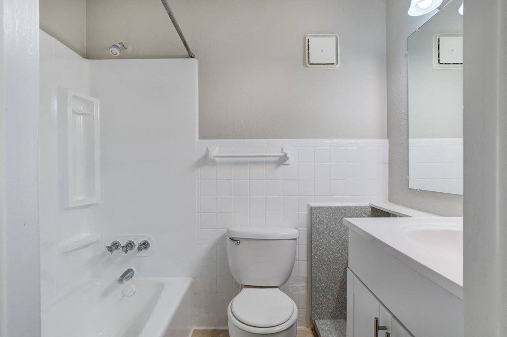 a bathroom with a toilet and a tub and a sink