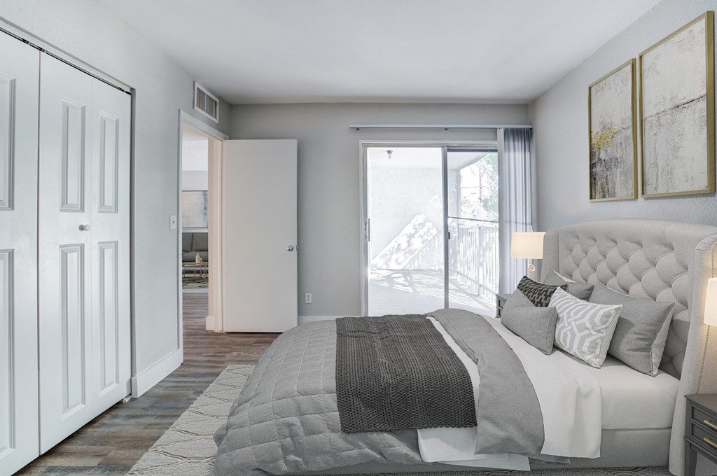 a bedroom with a bed and a door to a balcony