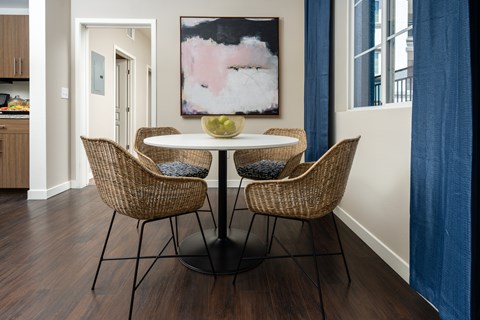 A dining room with a table and chairs.