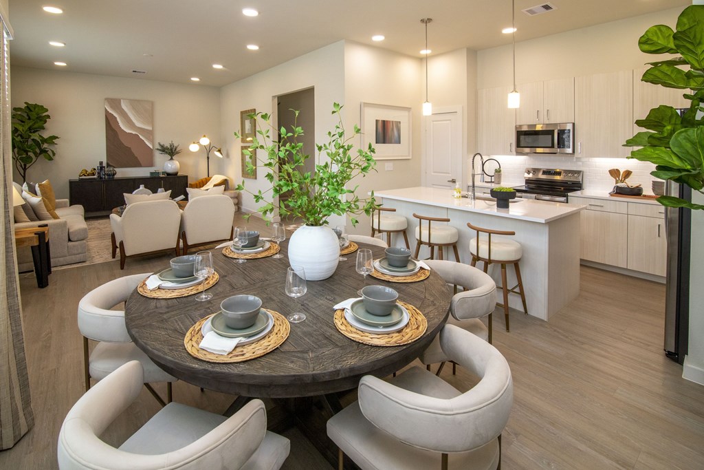 A modern dining room with a round table set for six.