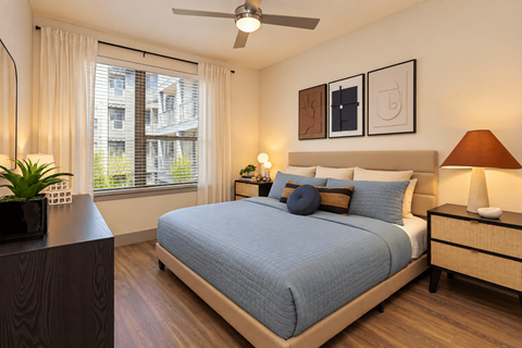 A bedroom with a bed, nightstand, and a ceiling fan.