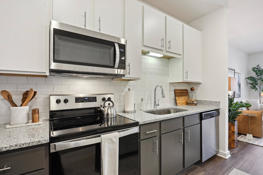 a kitchen with white cabinets and stainless steel appliances