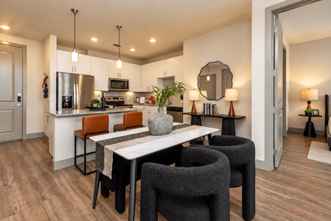 A modern kitchen with a dining table and chairs.