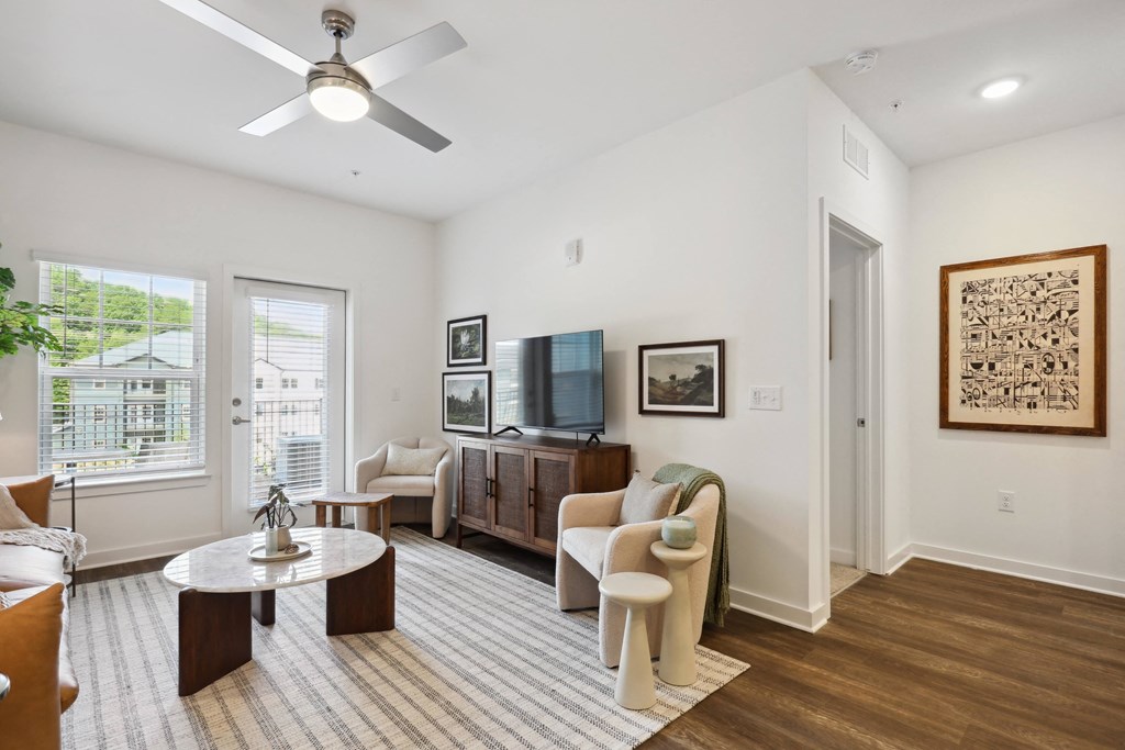 a living room with a ceiling fan and two windows