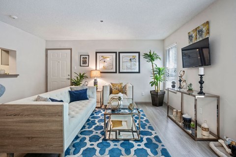 A bedroom with a bed, a chair, and a TV mounted on the wall.