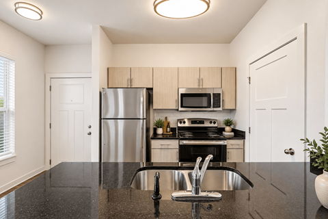 A kitchen with a black granite countertop and stainless steel appliances.