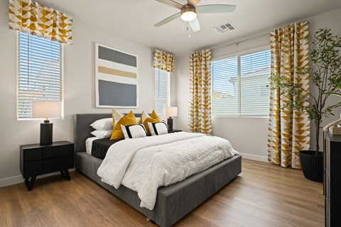 a bedroom with a bed and windows with yellow curtains