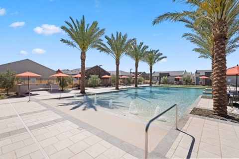 a swimming pool with palm trees and buildings in the background