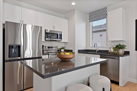 A modern kitchen with stainless steel appliances and white cabinets.