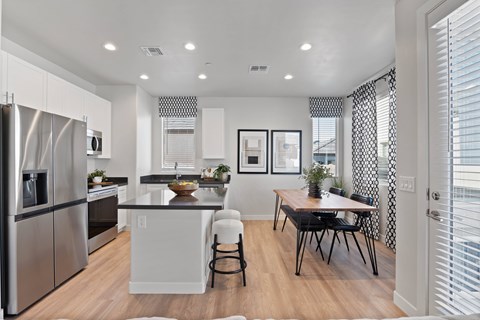 A modern kitchen with a dining table and chairs.