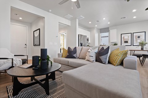 A modern living room with a grey sofa and a black coffee table.