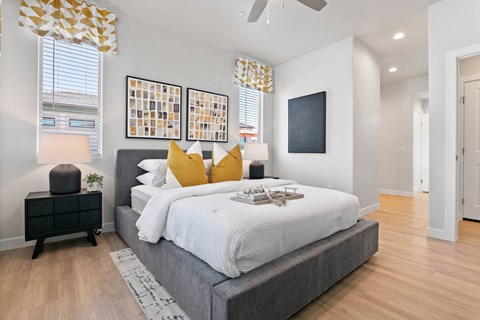 A bedroom with a large bed and a ceiling fan.