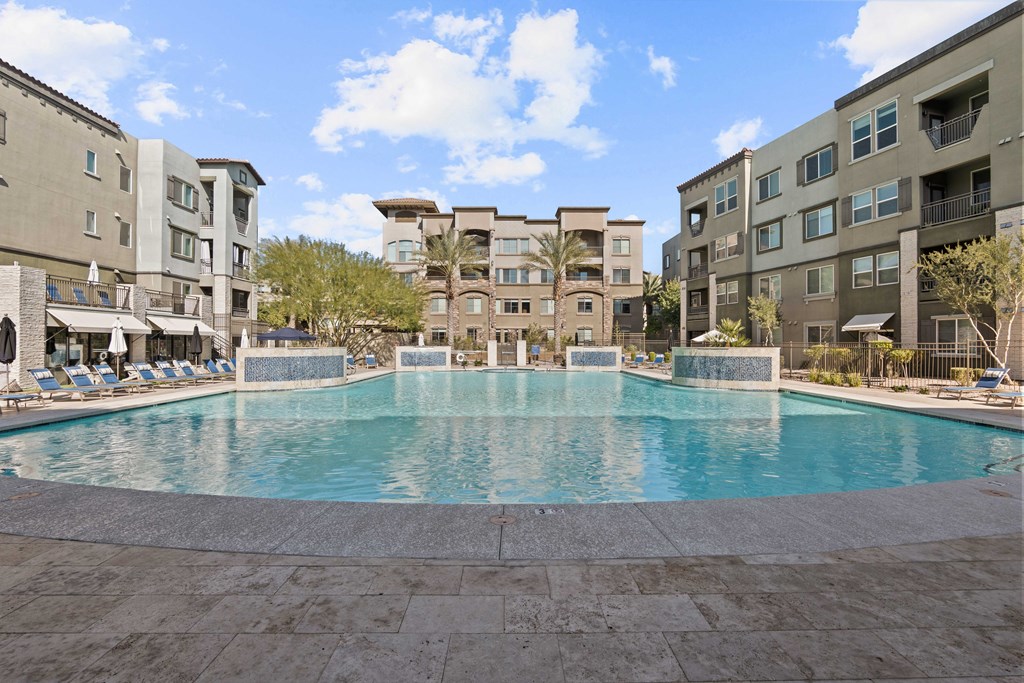 A large swimming pool in the middle of a courtyard surrounded by buildings.