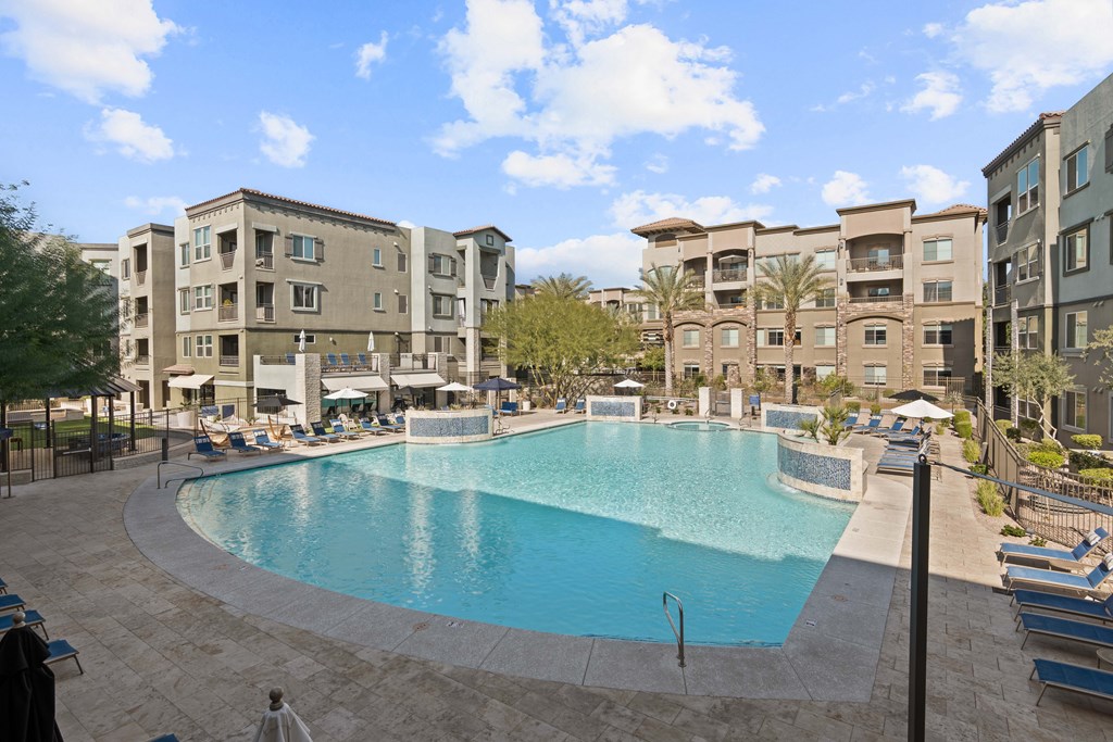 A large swimming pool surrounded by apartment buildings.
