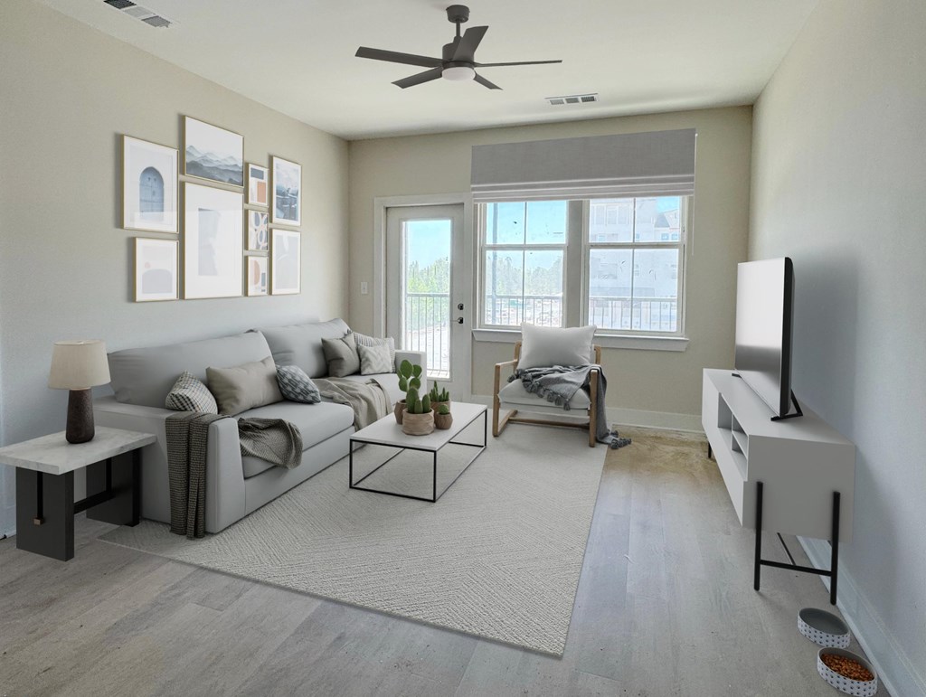 A living room with a grey couch, a coffee table, a television, and a ceiling fan.