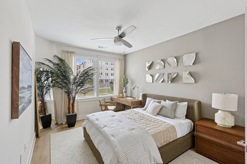 A bedroom with a large bed and a ceiling fan.
