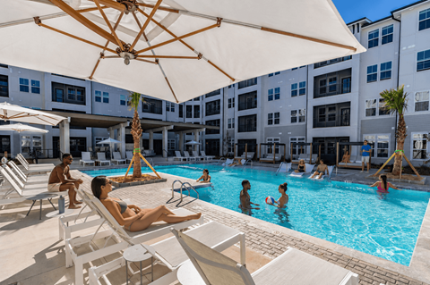 A group of people are enjoying a sunny day at the pool.