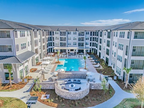 A large apartment complex with a pool and a patio area.