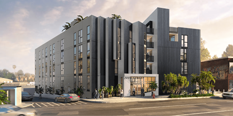 A modern building with a flat roof and a parking lot in front.