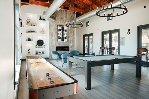 A pool table is in the middle of a room with a couch and a chair.