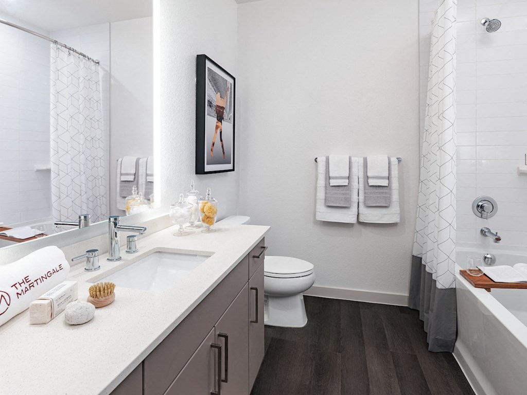 a bathroom with a bathtub toilet and shower stall in a 555 waverly unit