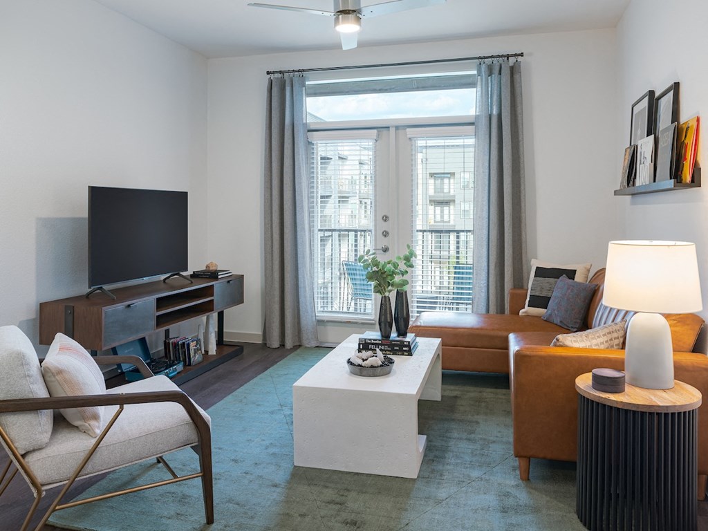 a living room with a brown couch and a white coffee table