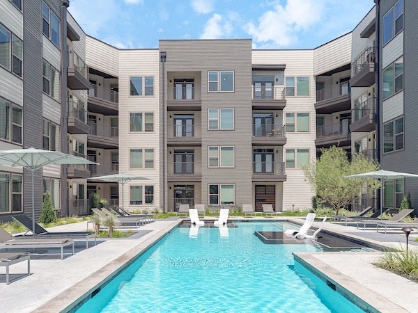 a rendering of an apartment building with a pool and lounge chairs