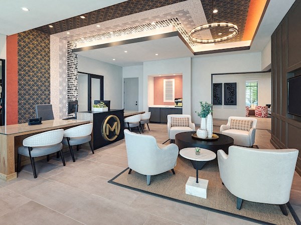 a lobby with chairs and tables and a reception desk