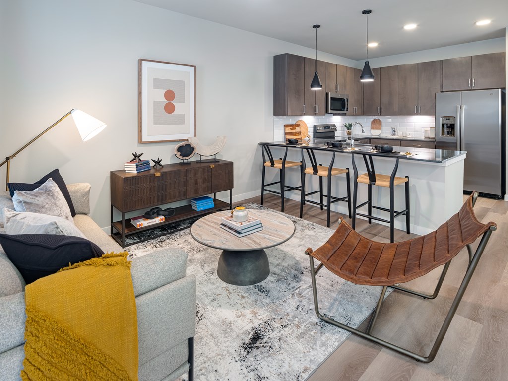 a living room with a couch and a table in front of a kitchen