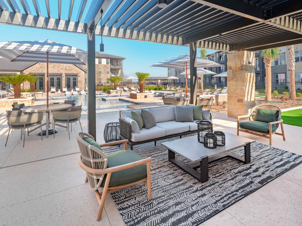 A patio with a table and chairs under a striped awning.