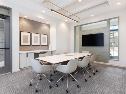 A conference room with a long table and chairs.