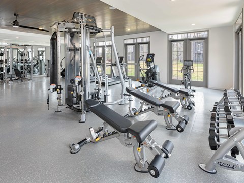 A spacious gym with a variety of equipment including treadmills, weights, and exercise machines.