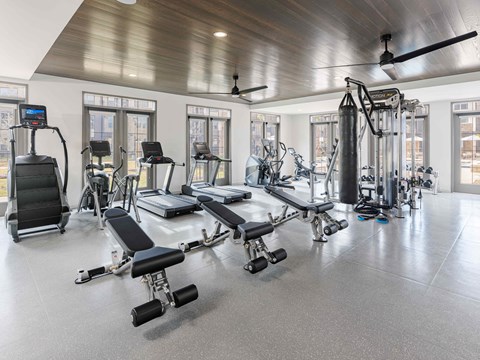 A spacious gym with a variety of equipment including treadmills, exercise bikes, and weight machines.