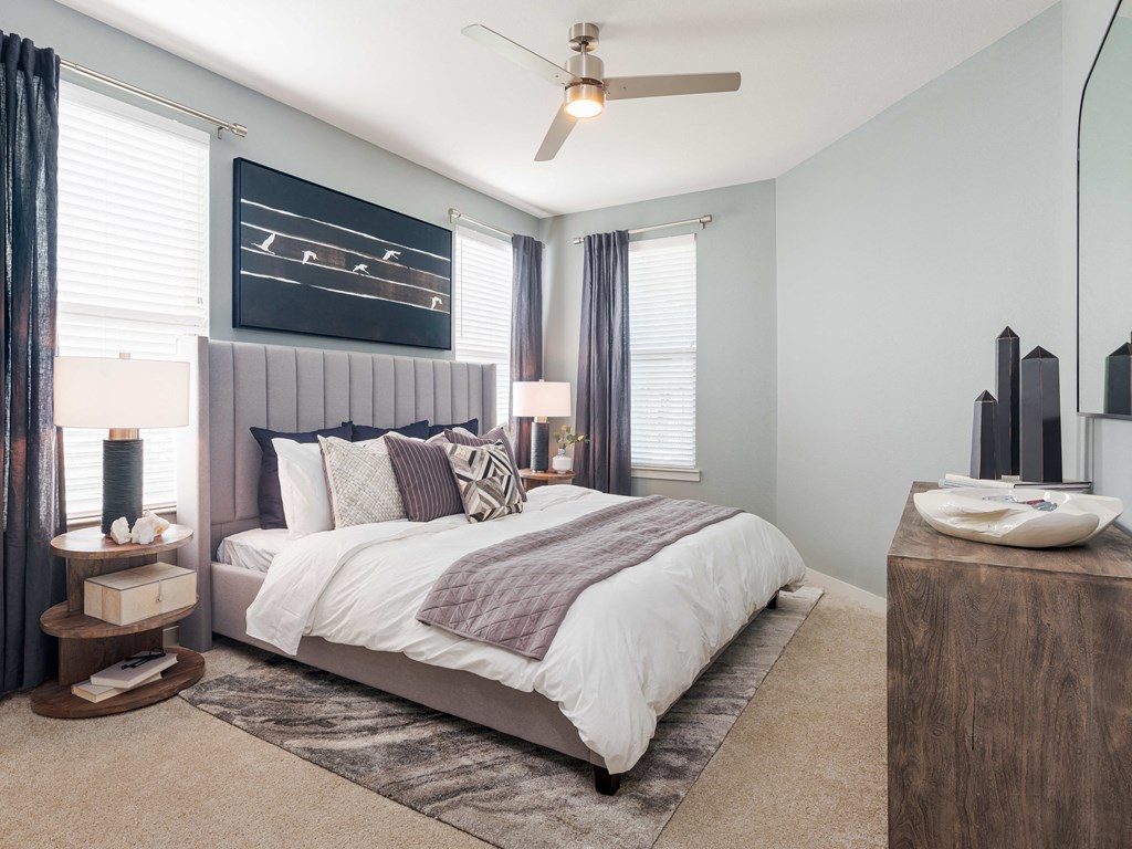 A bedroom with a large bed and a ceiling fan.