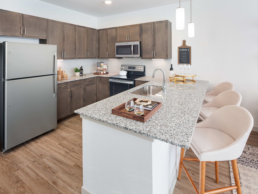 A kitchen with a granite countertop and a refrigerator.