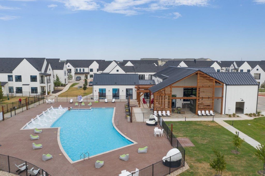 an aerial view of a swimming pool with an apartment building in the background
