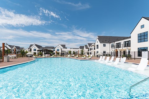 A large swimming pool in front of a row of houses.