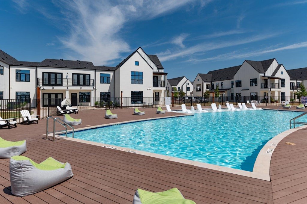 a large swimming pool in front of an apartment building