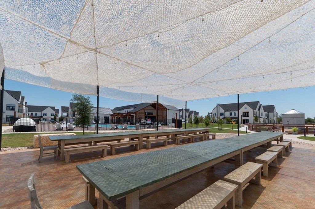 a picnic area with benches and a table under an umbrella