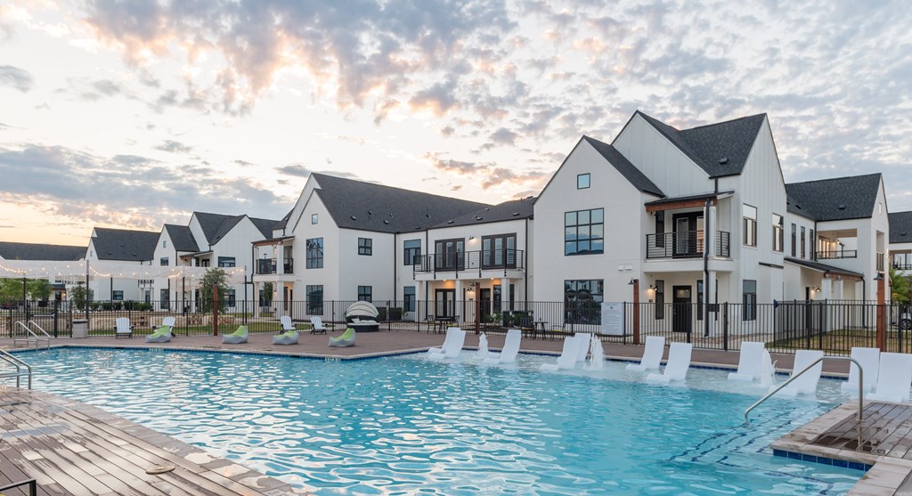 A large white building with a pool in front.