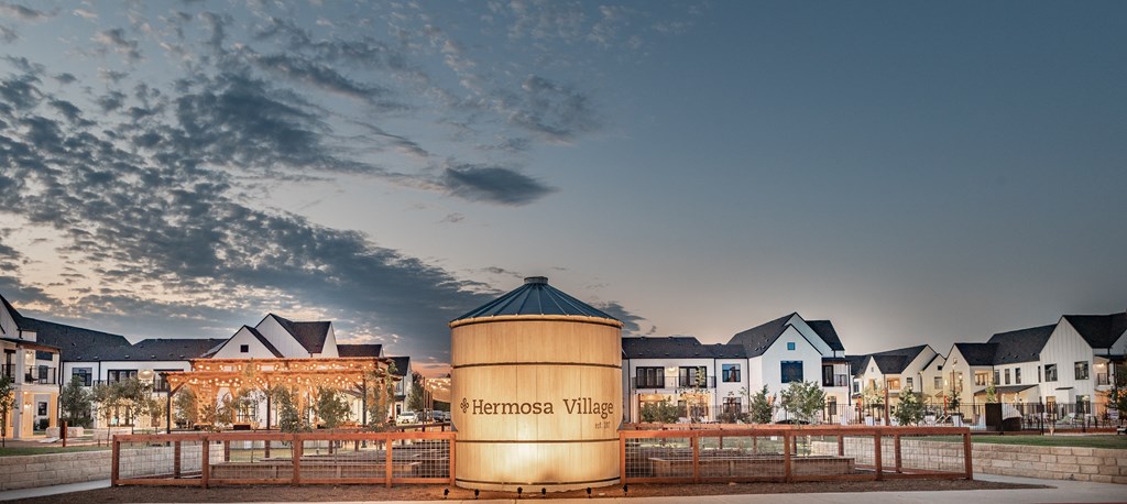 A modern building with a cylindrical structure in front labeled Hermosa Village.