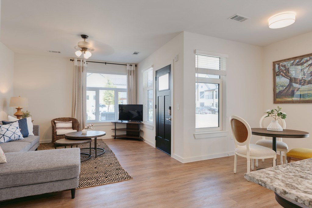 A living room with a grey sofa, a coffee table, a TV, and a painting on the wall.