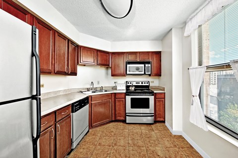 A kitchen with brown cabinets and white appliances.