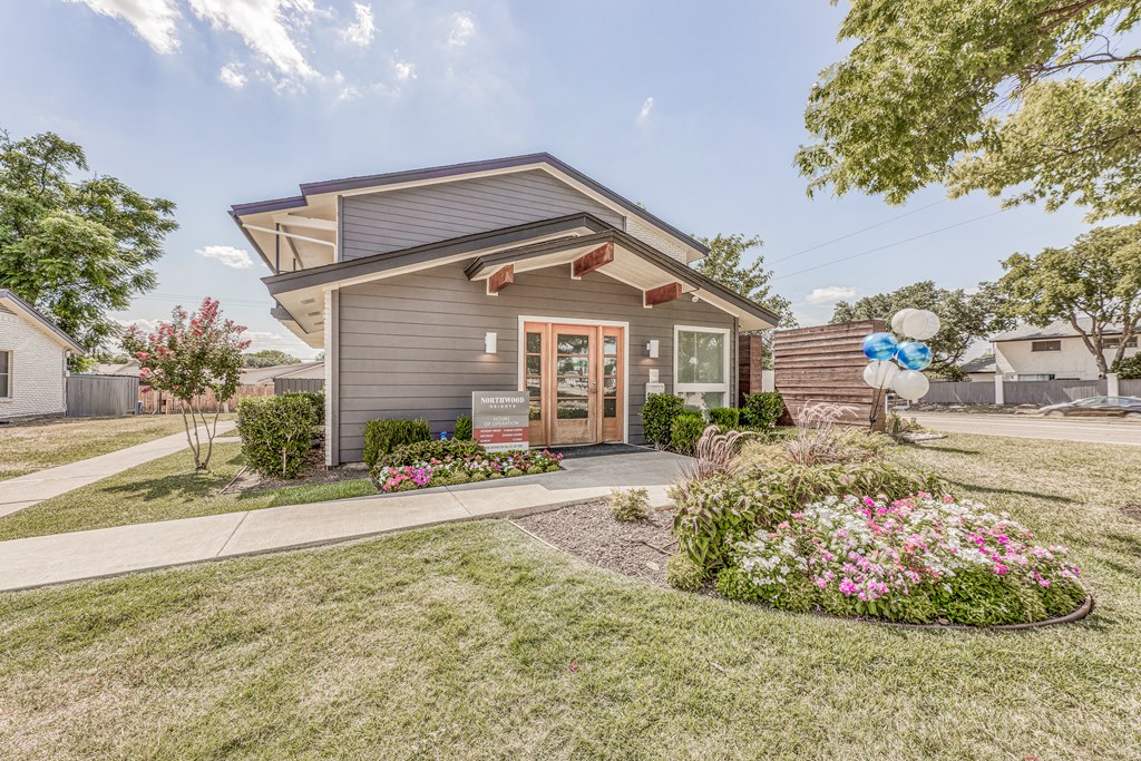 a small gray house with a yard and a sidewalk