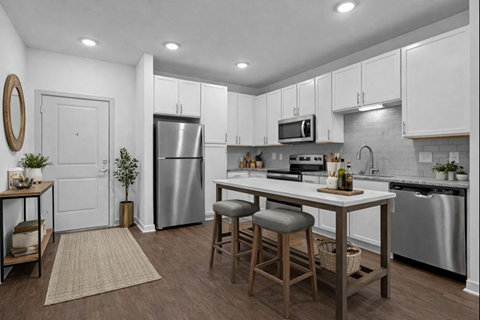 A kitchen with white cabinets and a wooden island.