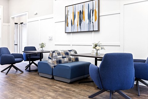 a living room with blue chairs and a table