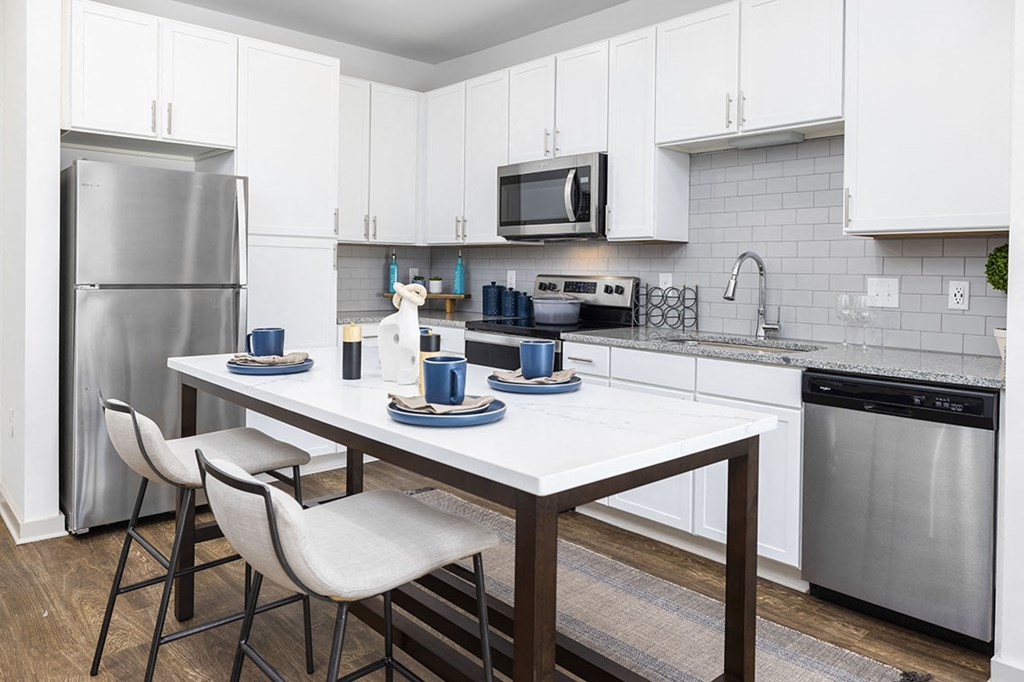 a kitchen with stainless steel appliances and a table with chairs