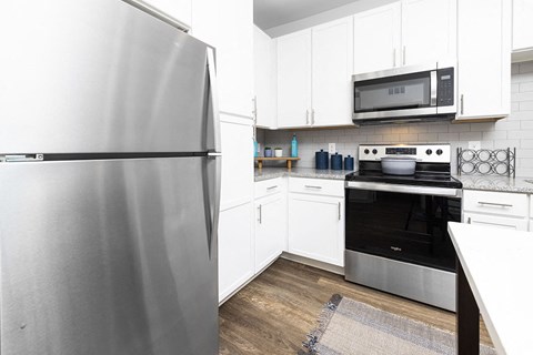 a kitchen with stainless steel appliances and white cabinets