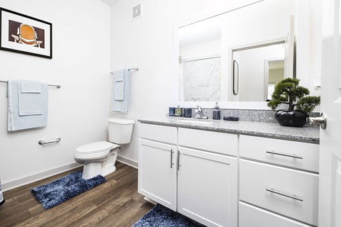 a bathroom with white cabinets and a toilet