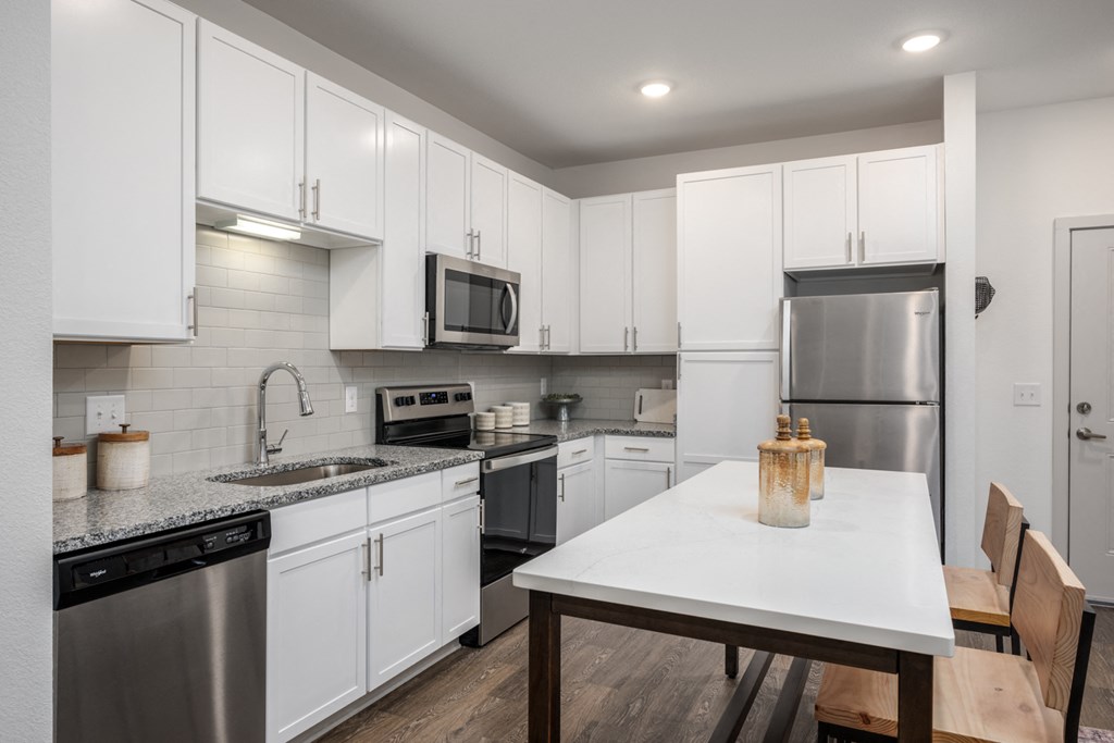 a kitchen with white cabinetry and stainless steel appliances